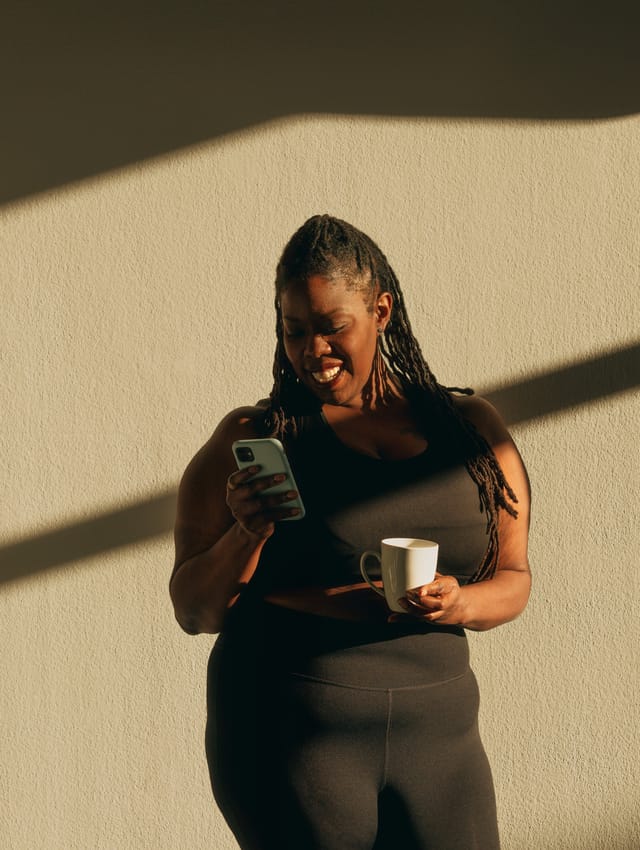 Business owner checking her phone over a coffee